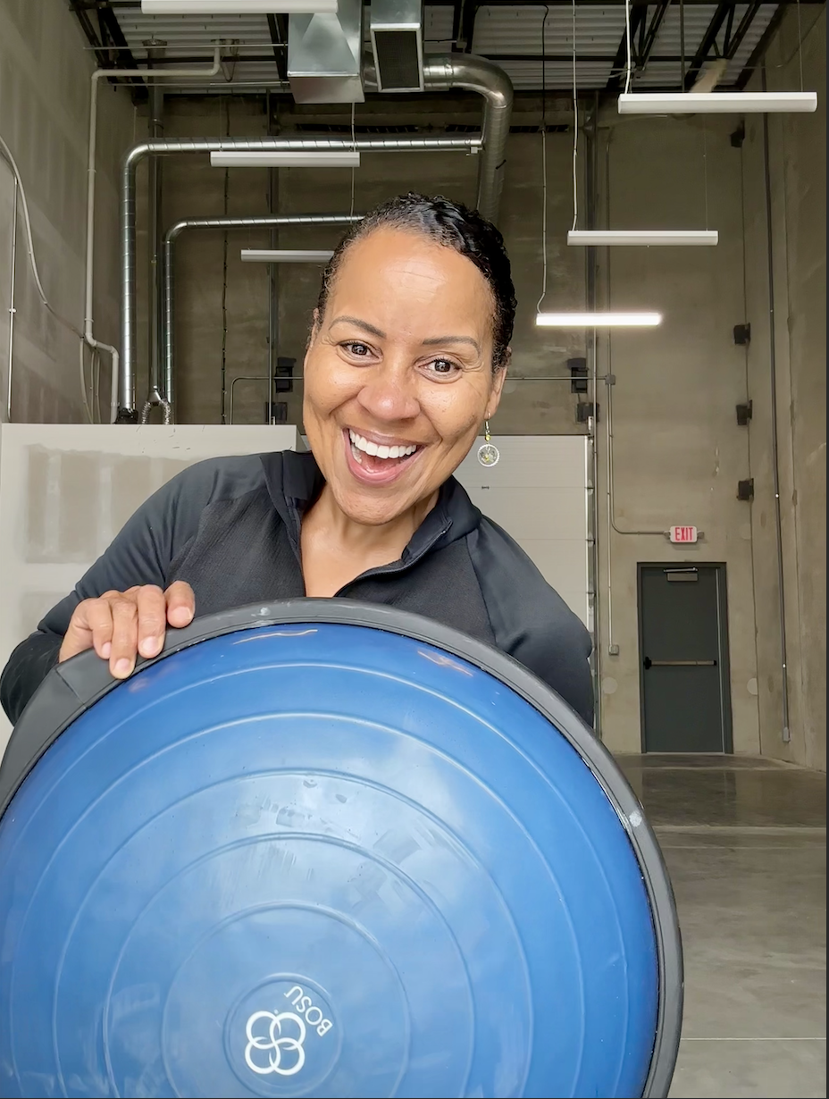 Roz Harris, owner of Emerge Personal Training, holding a BOSU ball in the studio